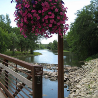 View of the Straight River from Morehouse Park with flowers in a hanging basket 